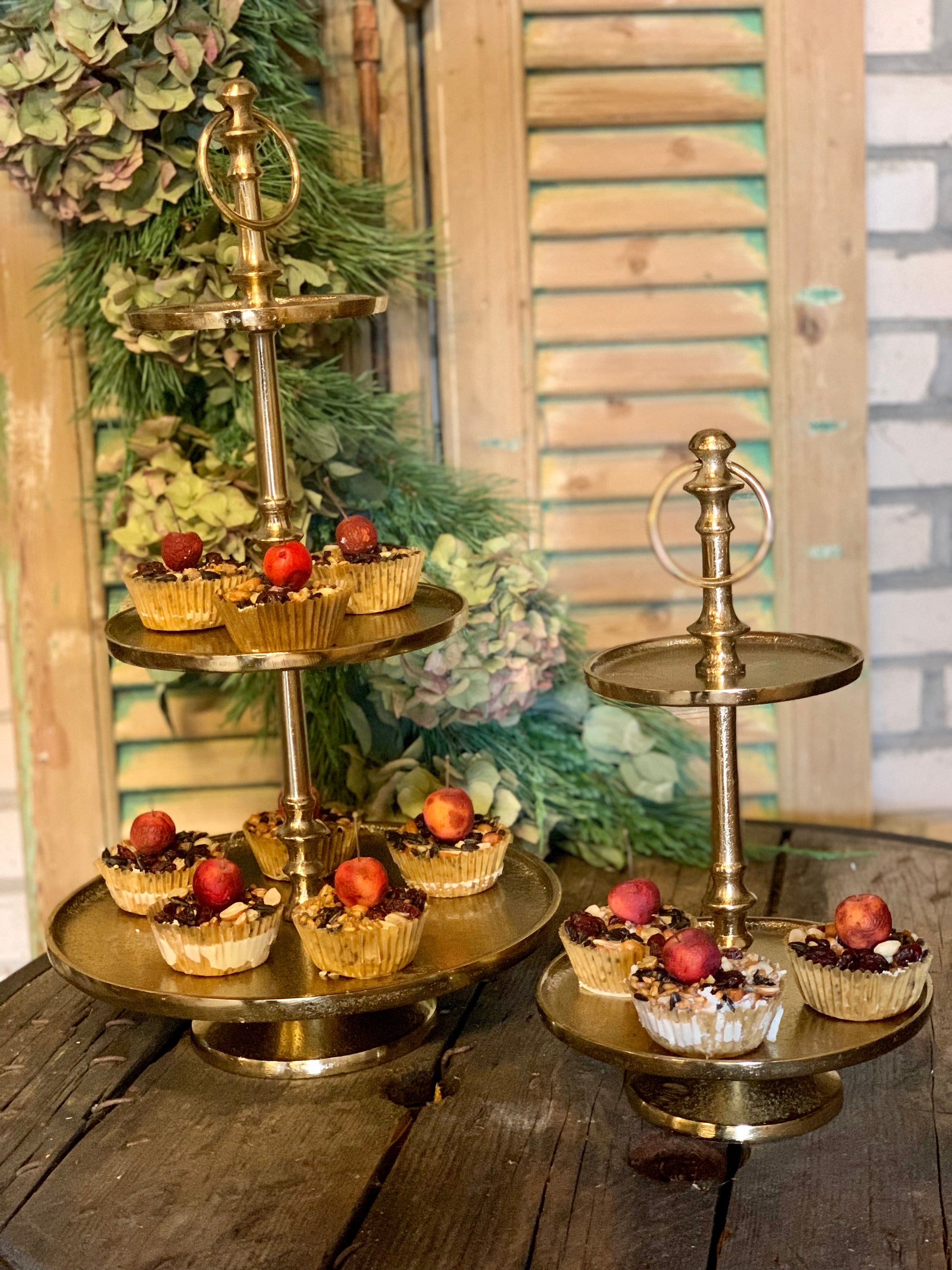 Elegante gouden taartstandaard met cupcakes en fruit, perfect voor feestelijke gelegenheden.