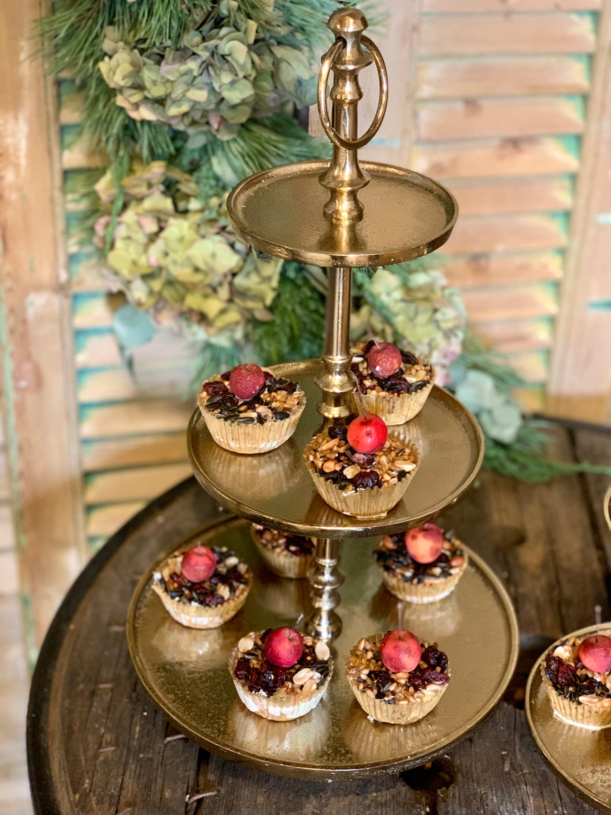 Elegante gouden taartstandaard met cupcakes en fruit, perfect voor feestelijke gelegenheden.